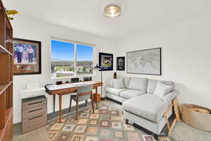 Bright room featuring a large window, a wood-finish built-in bookshelf, and recessed lighting