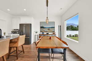 Open-concept dining area featuring wood-finish flooring and a rectangular window