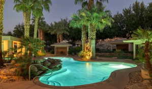 Curved swimming pool with integrated rock features and metal handrails