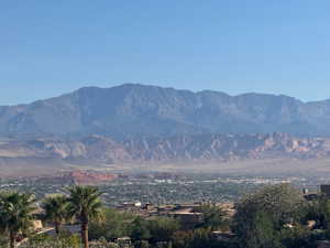 Expansive desert landscape with multiple mountain ranges and distant city elements