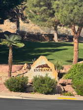 Stone entrance monument featuring custom lettering, surrounded by varied landscaping with mature trees and manicured lawn