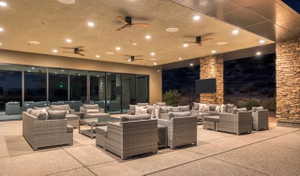 Expansive covered patio featuring recessed lighting, multiple ceiling fans, and a large flat-panel screen