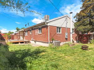 Brick exterior with white siding accents and a wooden deck