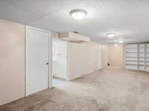 Spacious room featuring neutral carpeting, multiple doors, and built-in shelving