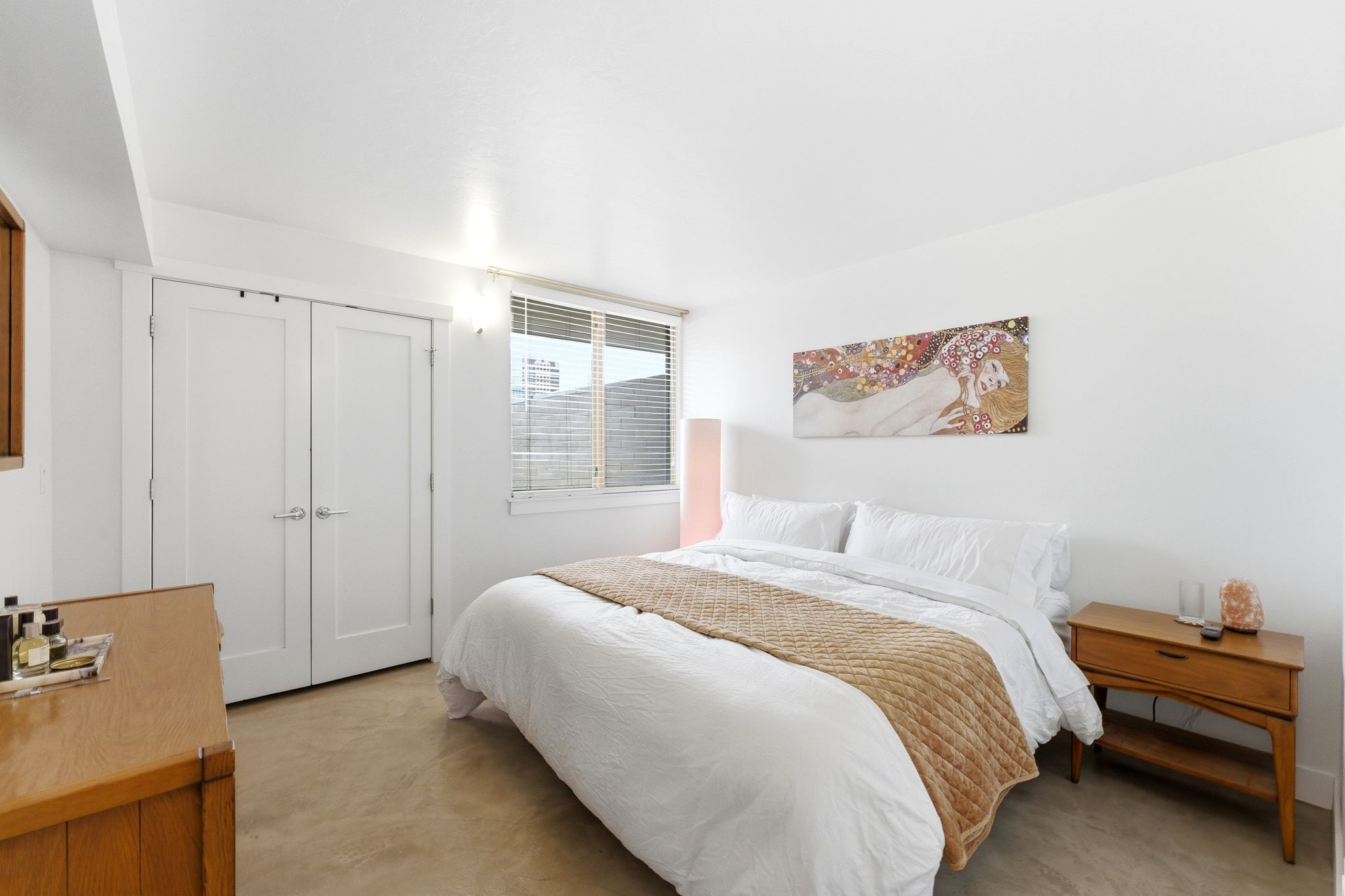 Bedroom featuring light-colored flooring, white walls, and a window with blinds