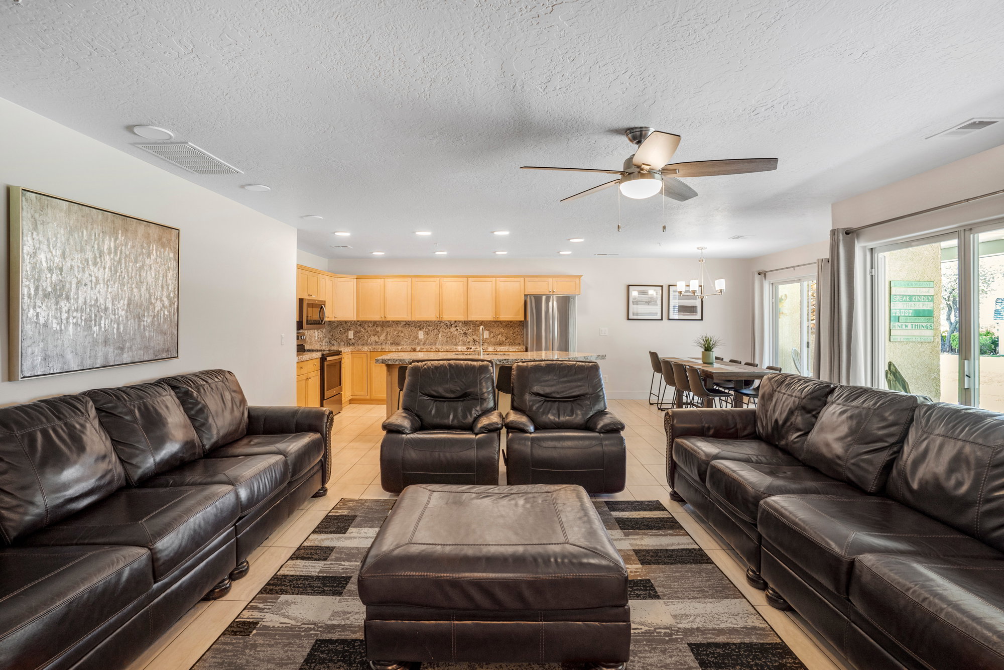 Open-concept living space featuring light-toned flooring, recessed lighting, and a ceiling fan