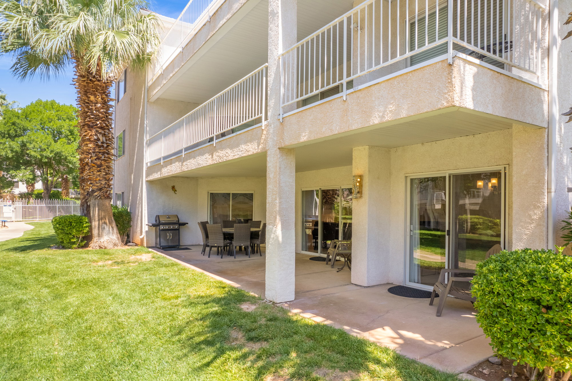 Ground-level unit with a private patio offering direct access to a manicured lawn