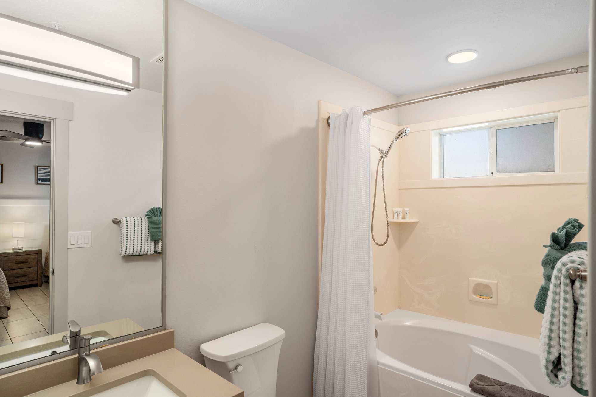 Bathroom featuring a single vanity with a solid surface countertop, an undermount sink, and a brushed nickel faucet