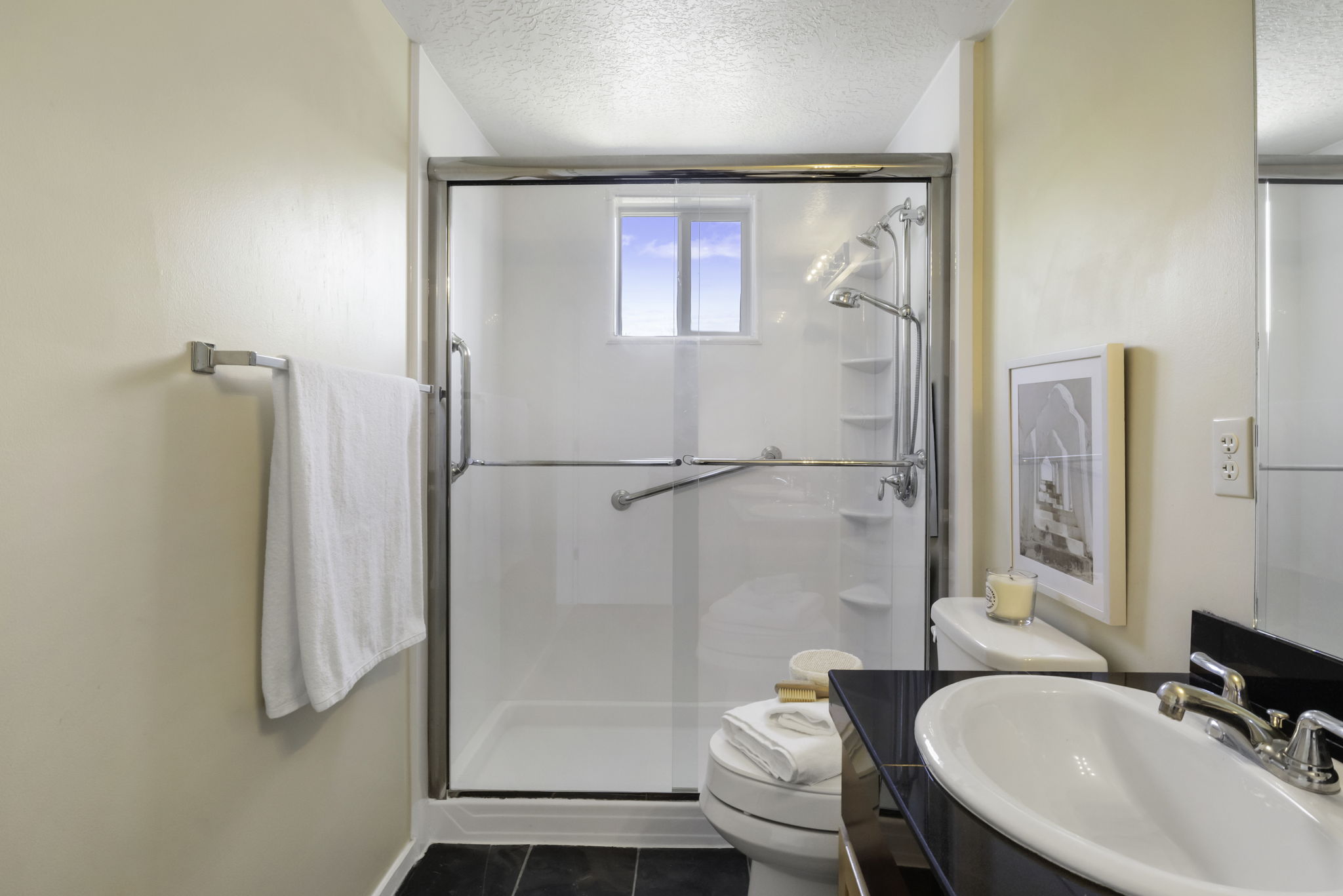 Bathroom featuring a shower with glass enclosure, window, and integrated shelving