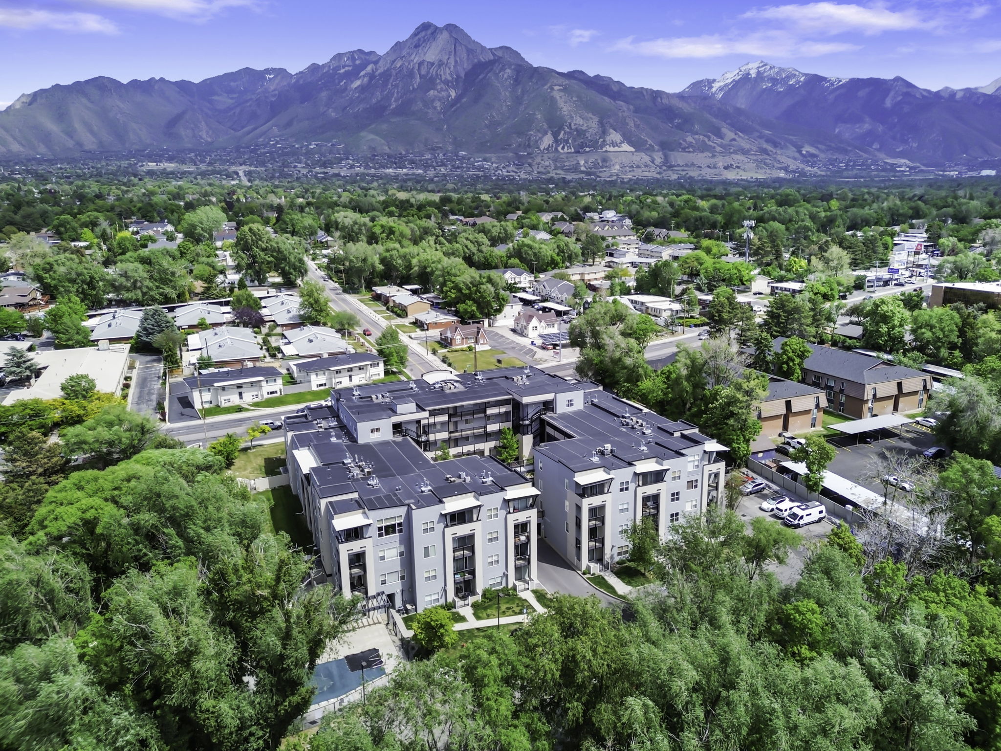 Modern multi-story buildings featuring a flat roof design and multiple balconies
