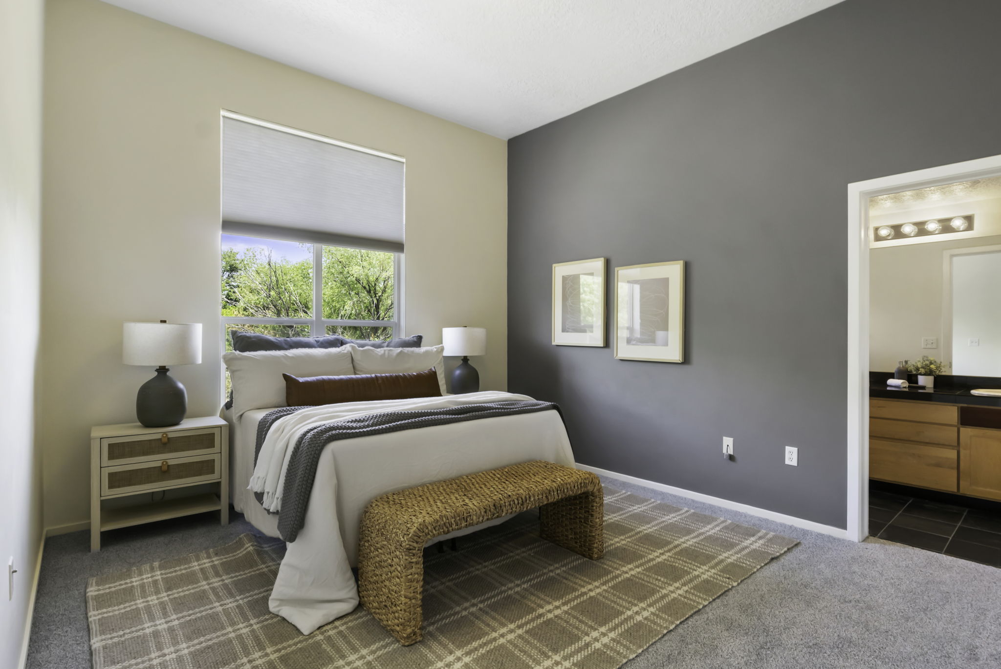 Bedroom featuring a large window, soft gray carpeting, and a contrasting accent wall