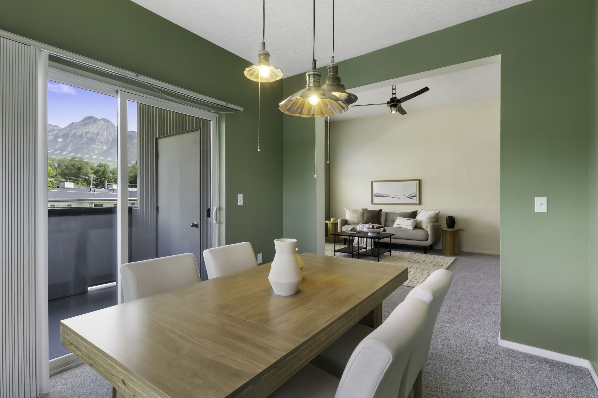 Dining area featuring a wood-finish table, pendant lighting, and a sliding glass door leading to a balcony