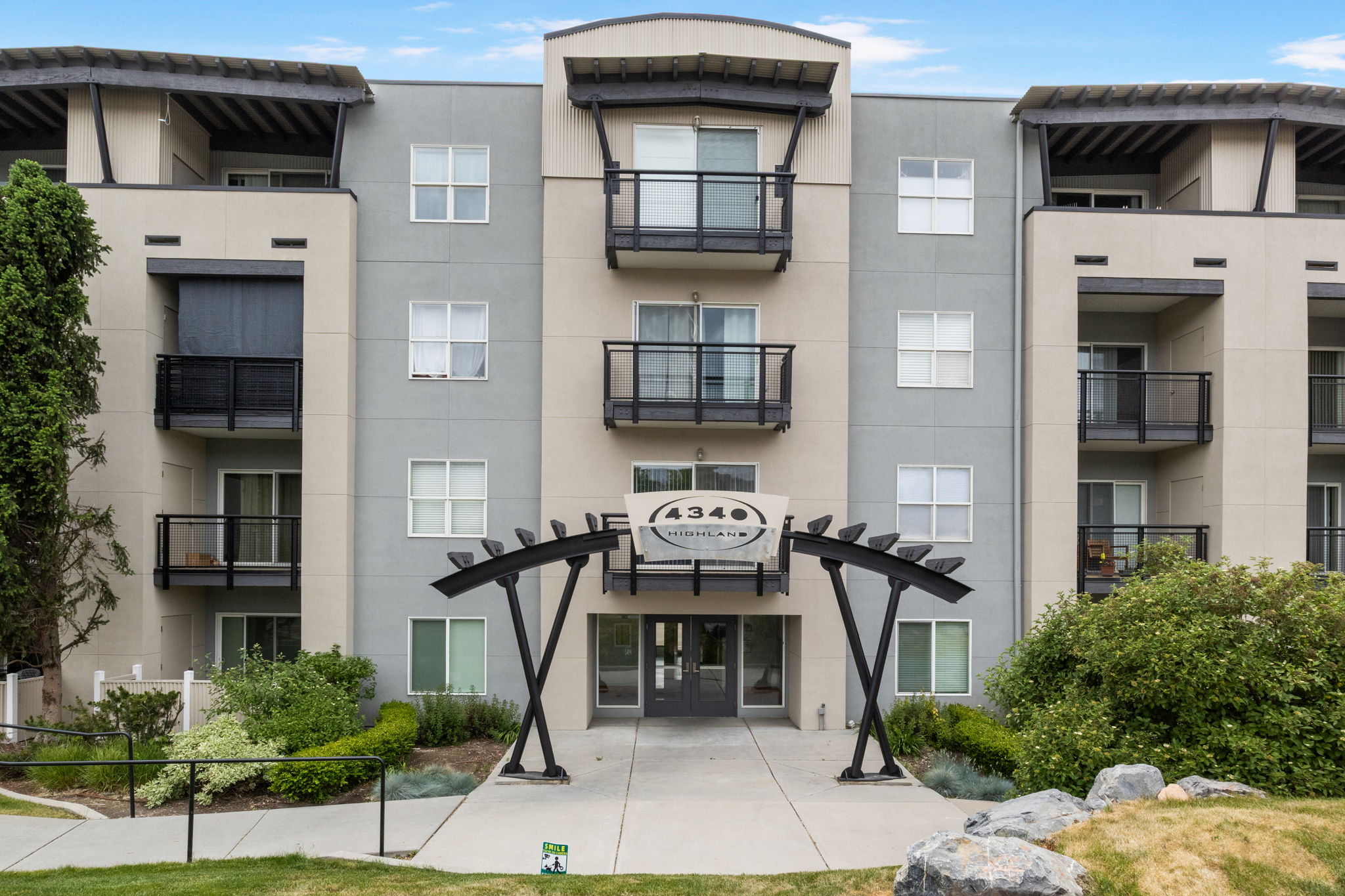 Modern multi-story building featuring a neutral color palette with light beige and grey facade panels