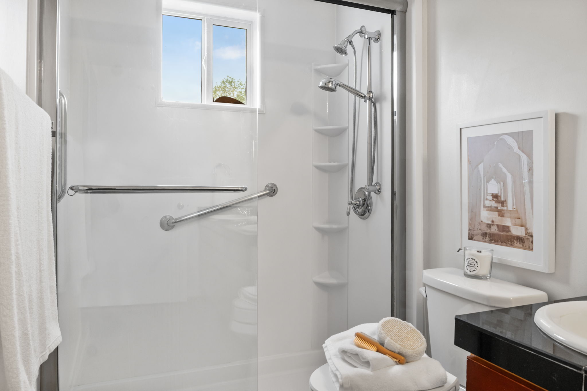 Shower enclosure featuring a built-in window, a dual shower head system, and integrated corner shelving