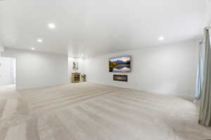 Spacious room featuring light-toned carpeting and recessed lighting