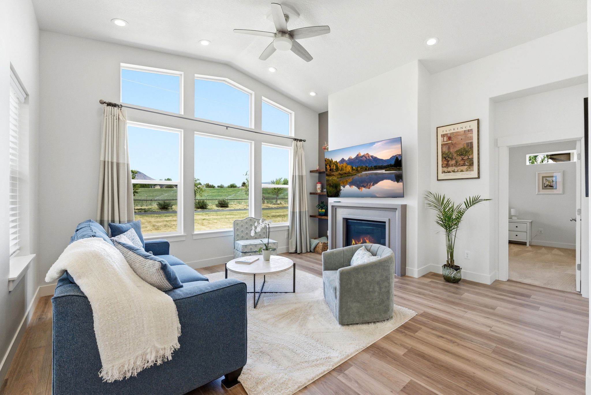 Vaulted living room featuring wood-finish flooring, a contemporary ceiling fan, and recessed lighting