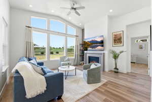 Vaulted living room featuring wood-finish flooring, a contemporary ceiling fan, and recessed lighting