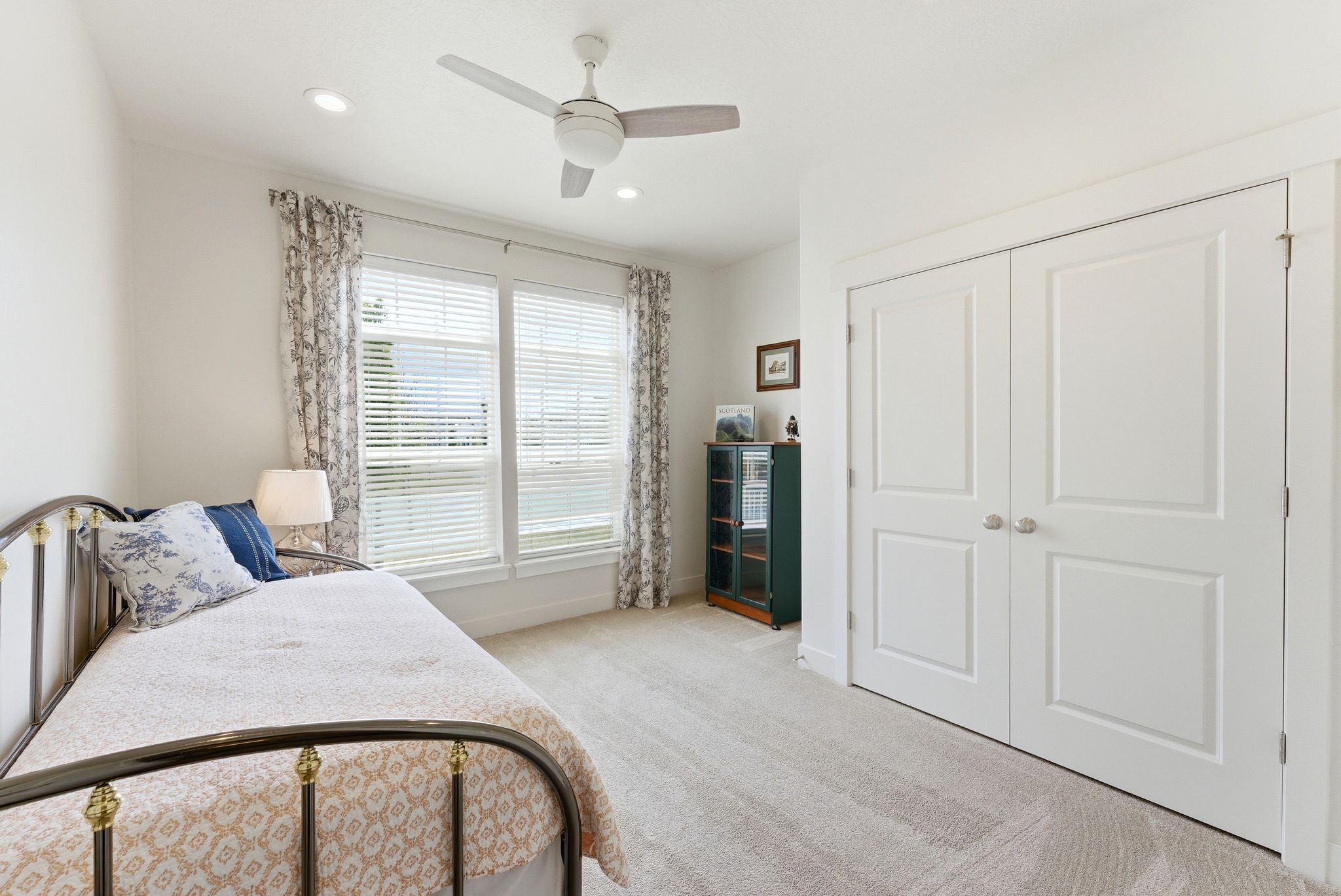 Bright room featuring a window with blinds and drapes, recessed lighting, a ceiling fan, plush carpet flooring, and double bifold closet doors