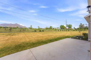 Expansive grassy yard with mountain backdrop and sprinkler system