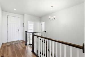 Entryway featuring wood-finish flooring, white paneled door, and recessed lighting
