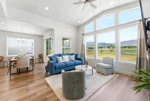Living area featuring wood-finish flooring and a vaulted ceiling with recessed lighting
