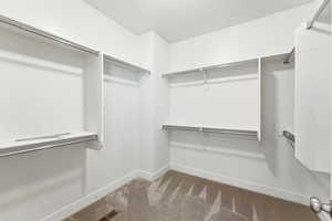 Walk-in closet featuring extensive built-in shelving and multiple hanging rods