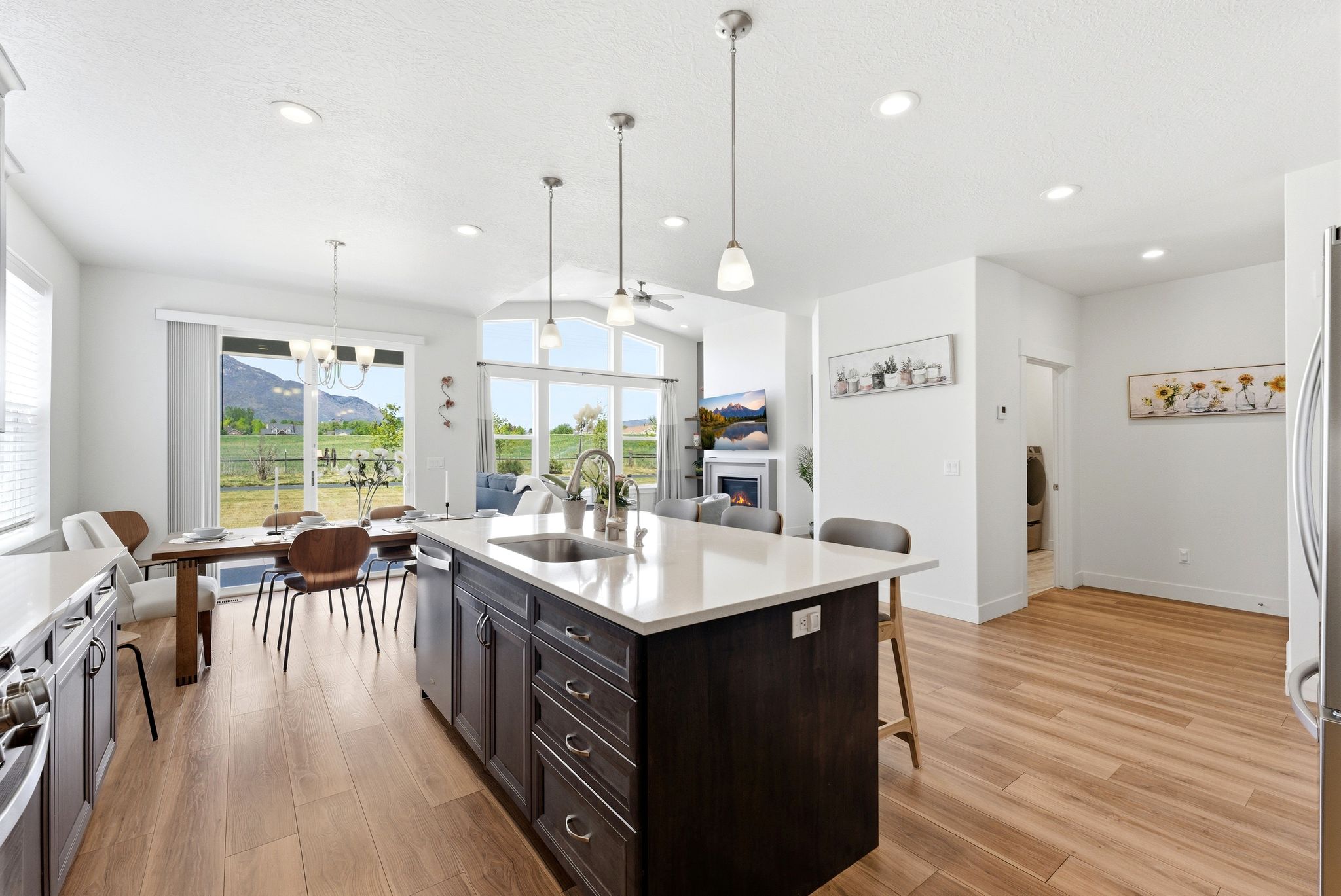 Open-concept interior featuring wood-finish flooring, recessed lighting, and a kitchen island with seating