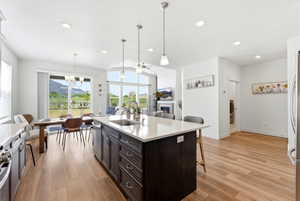 Open-concept interior featuring wood-finish flooring, recessed lighting, and a kitchen island with seating