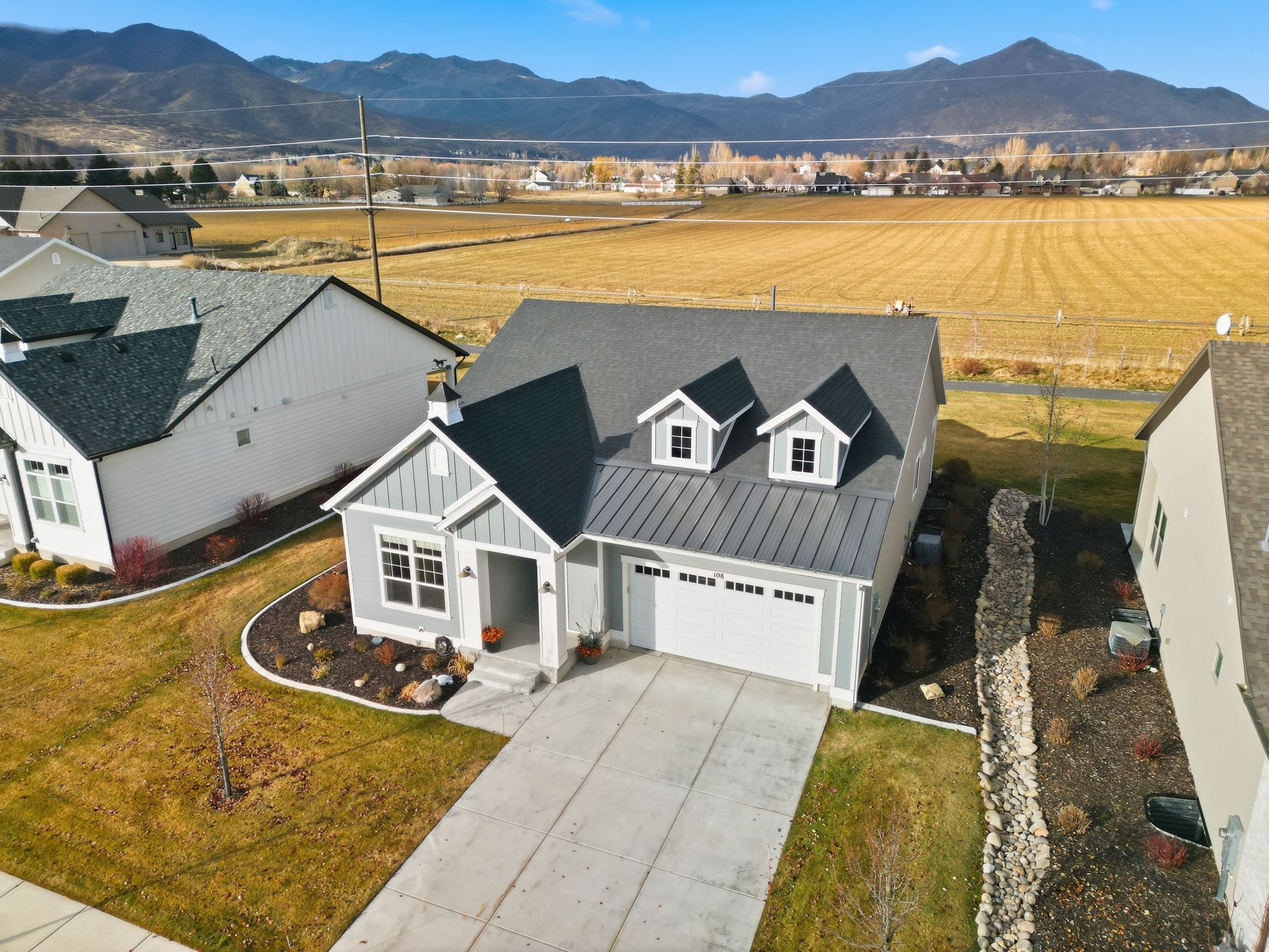 Contemporary home featuring a light gray exterior, a two-car garage, and a concrete driveway