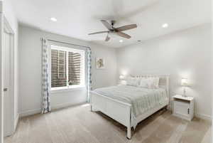 Bright bedroom featuring light neutral walls and coordinating carpet flooring