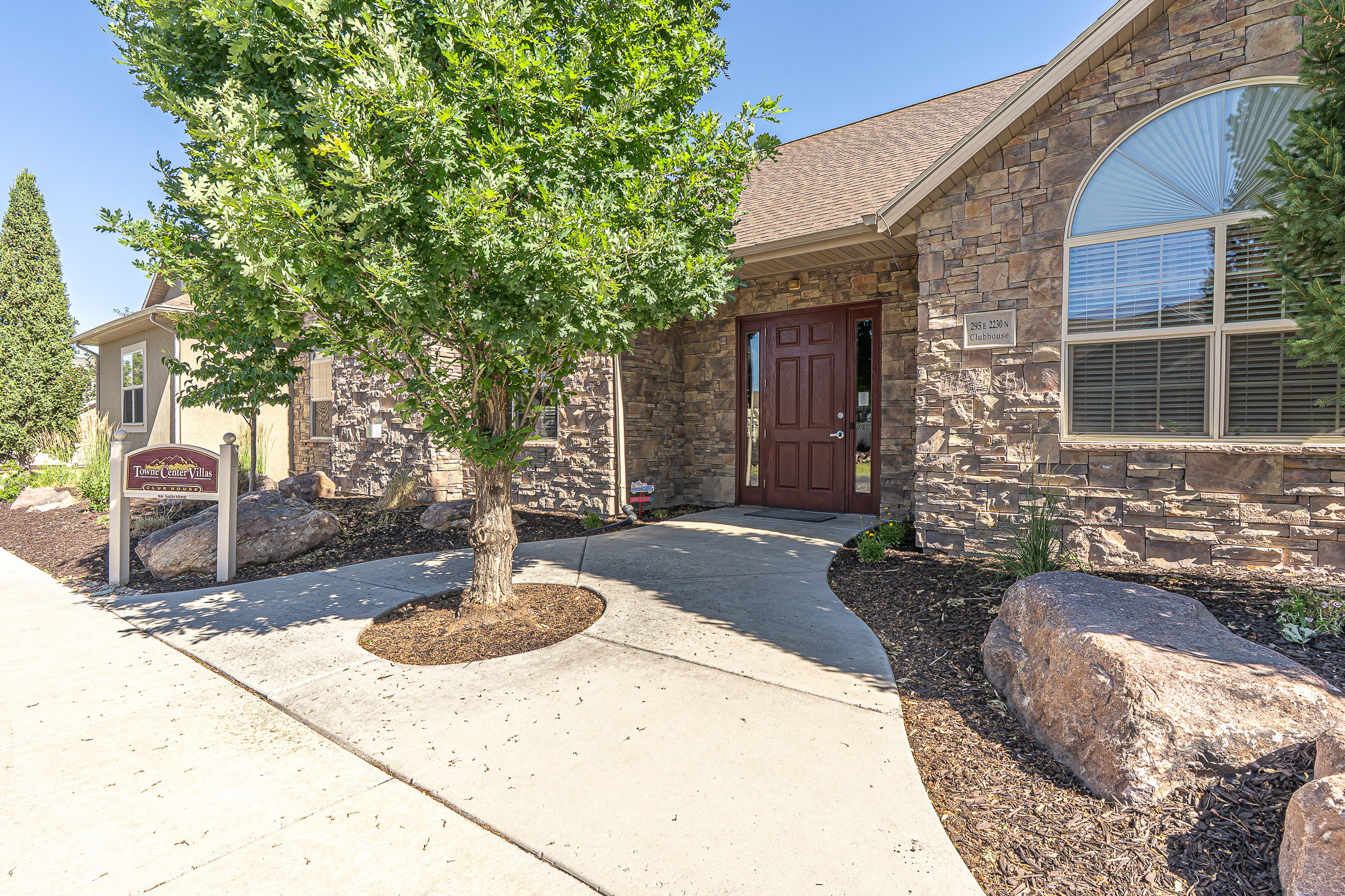 Stone veneer facade featuring a prominent arched window and a wood-paneled entry door