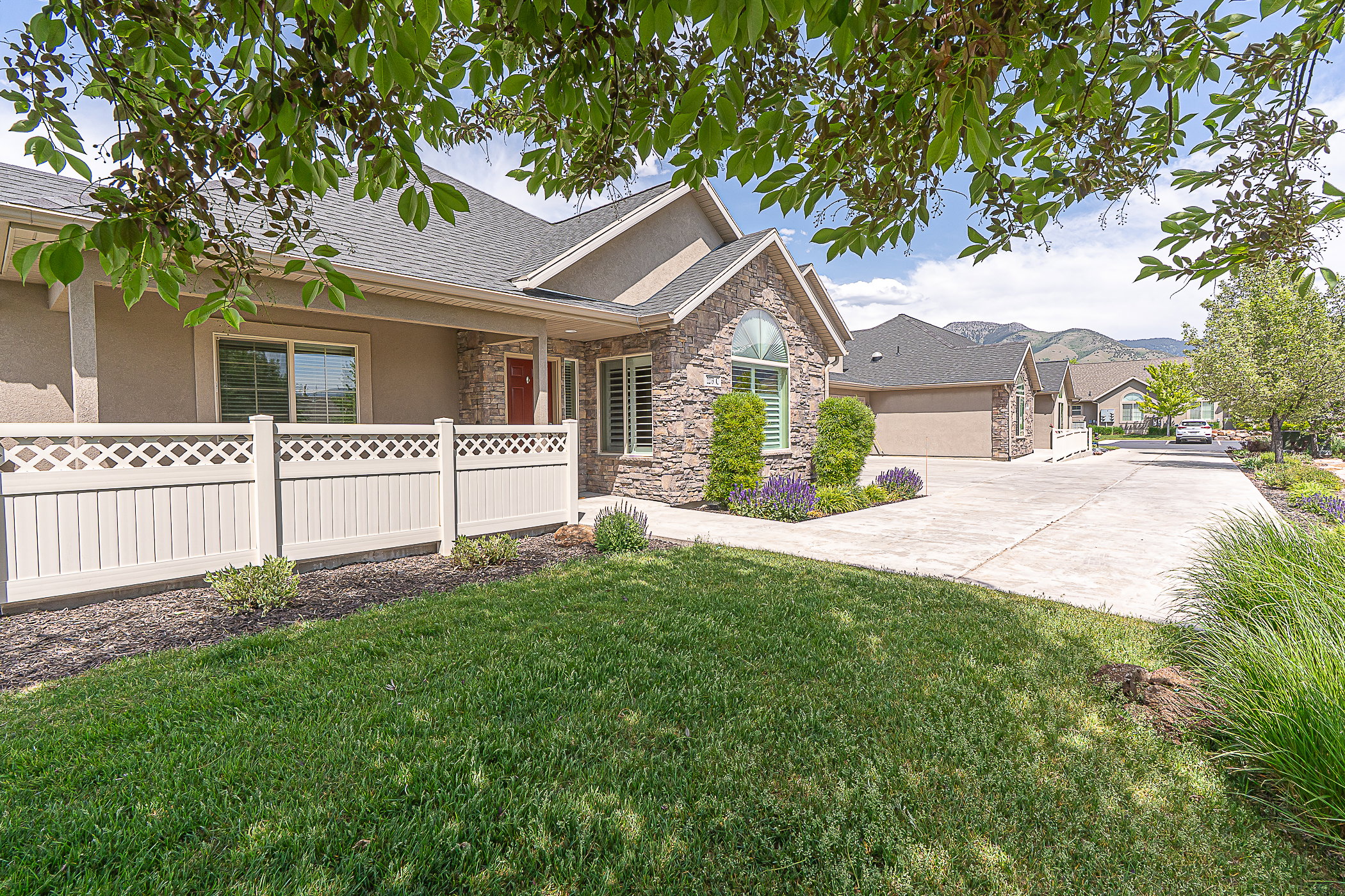 Stone veneer and stucco exterior with a gray shingle roof