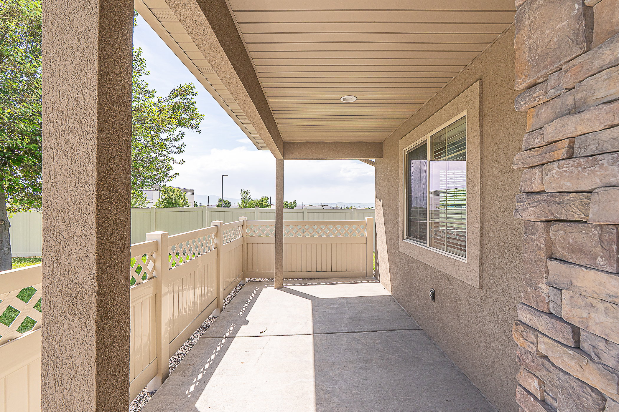 Covered patio featuring concrete flooring and a privacy fence