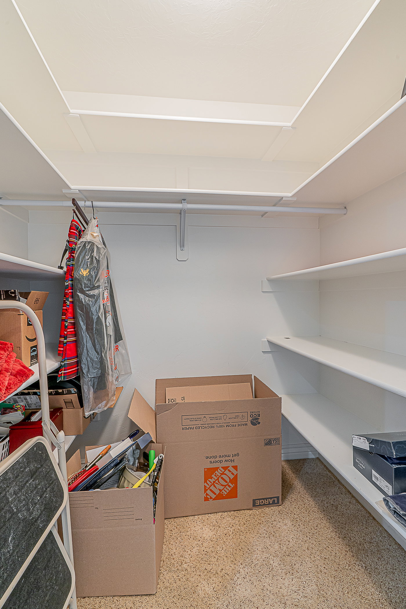 Additional storage closet featuring white built-in shelving, white walls, and light-toned carpet flooring and access to CRAWL SPACE