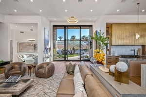 Expansive living area with large format sliding glass doors, recessed lighting, and wood-finish flooring