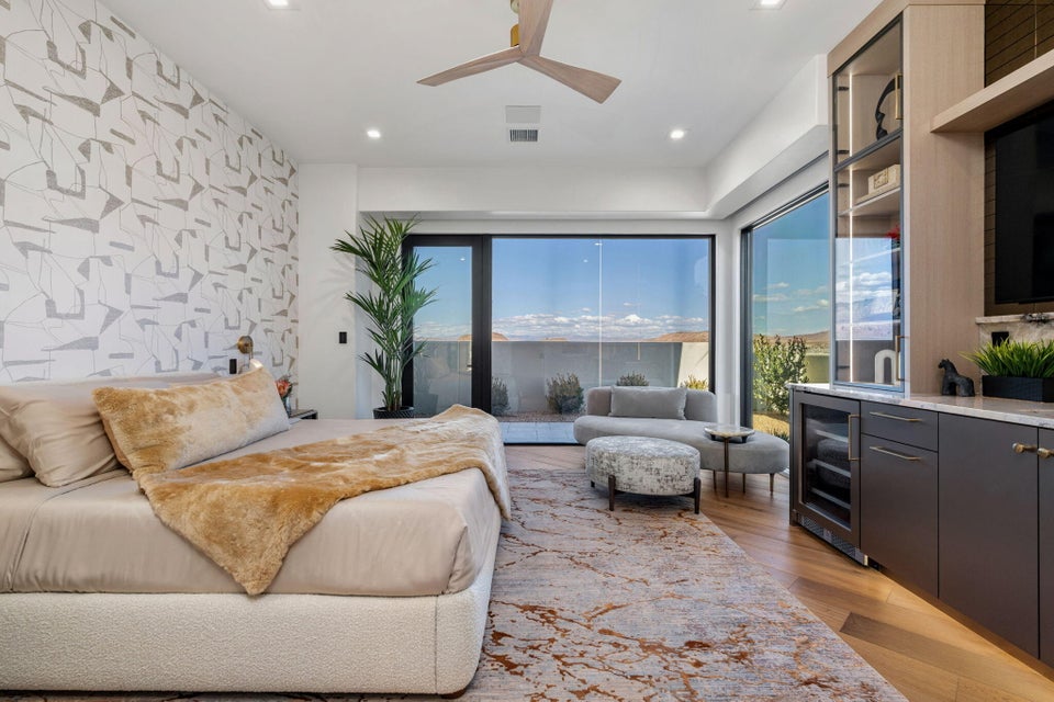 Spacious room featuring wood-finish flooring, a wall of glass sliding doors, and a built-in media center with a beverage refrigerator