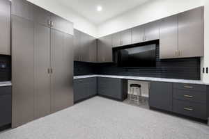Custom storage system featuring extensive cabinetry, integrated workspace, durable epoxy flooring, and full-height built-in units