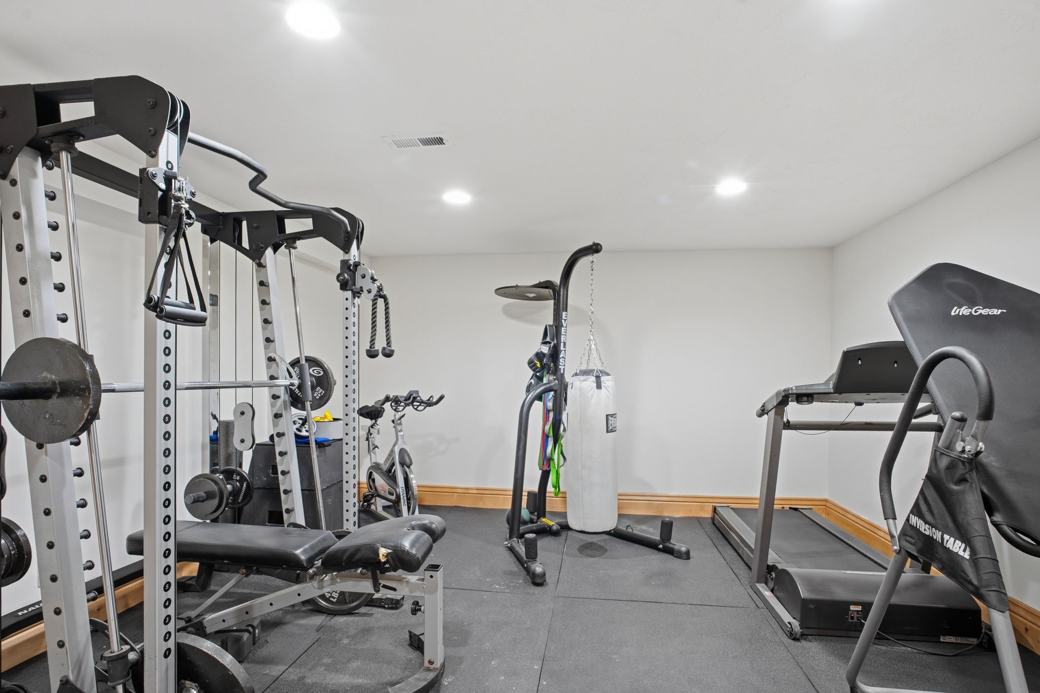 Dedicated fitness space featuring rubberized flooring, recessed lighting, and wood baseboards