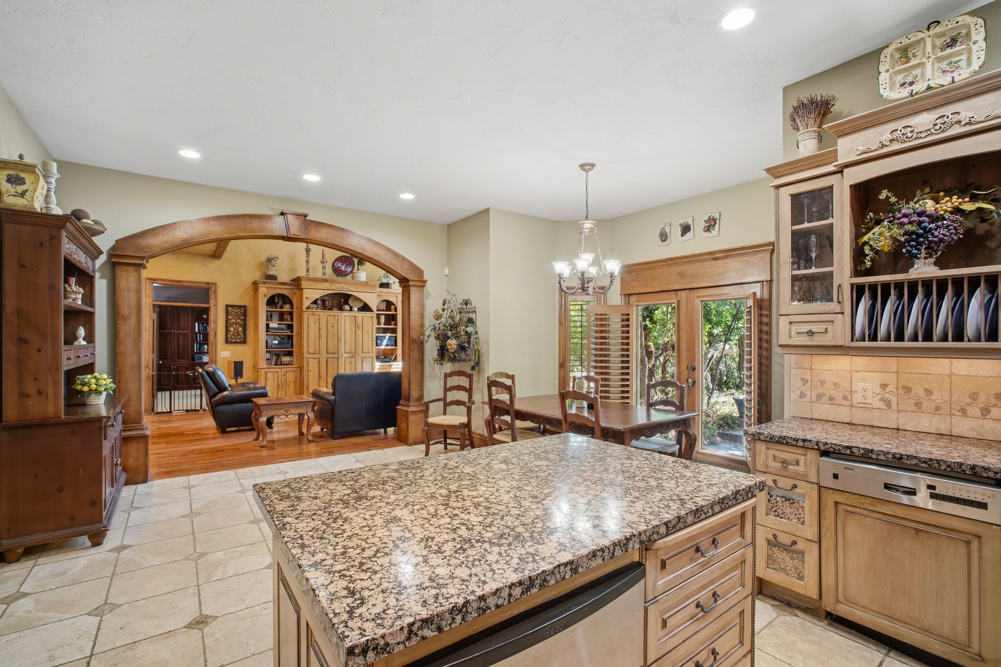 Kitchen featuring a granite-topped island, light wood cabinetry, and tile flooring