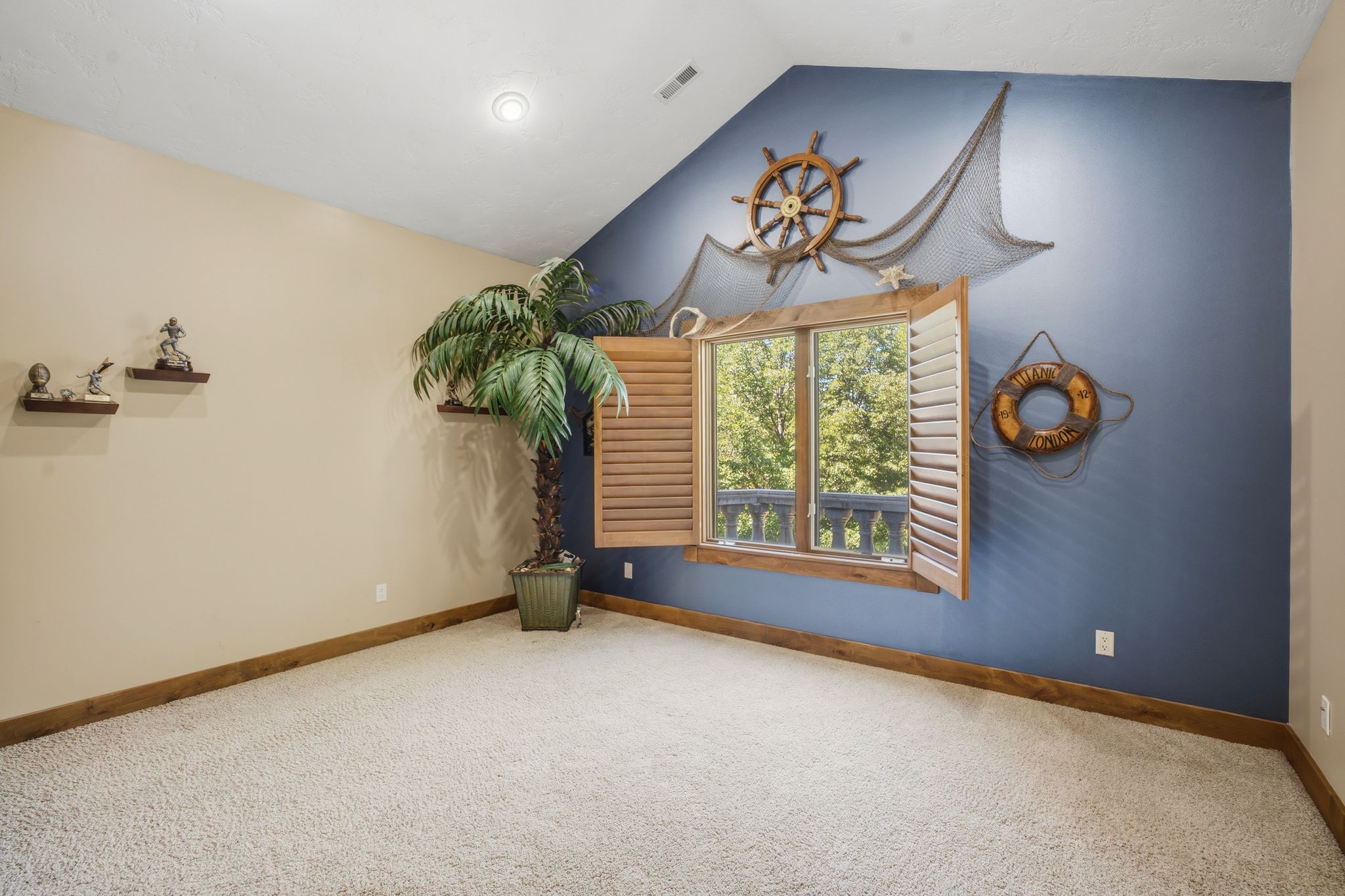 Window with louvered shutters, complemented by a blue accent wall