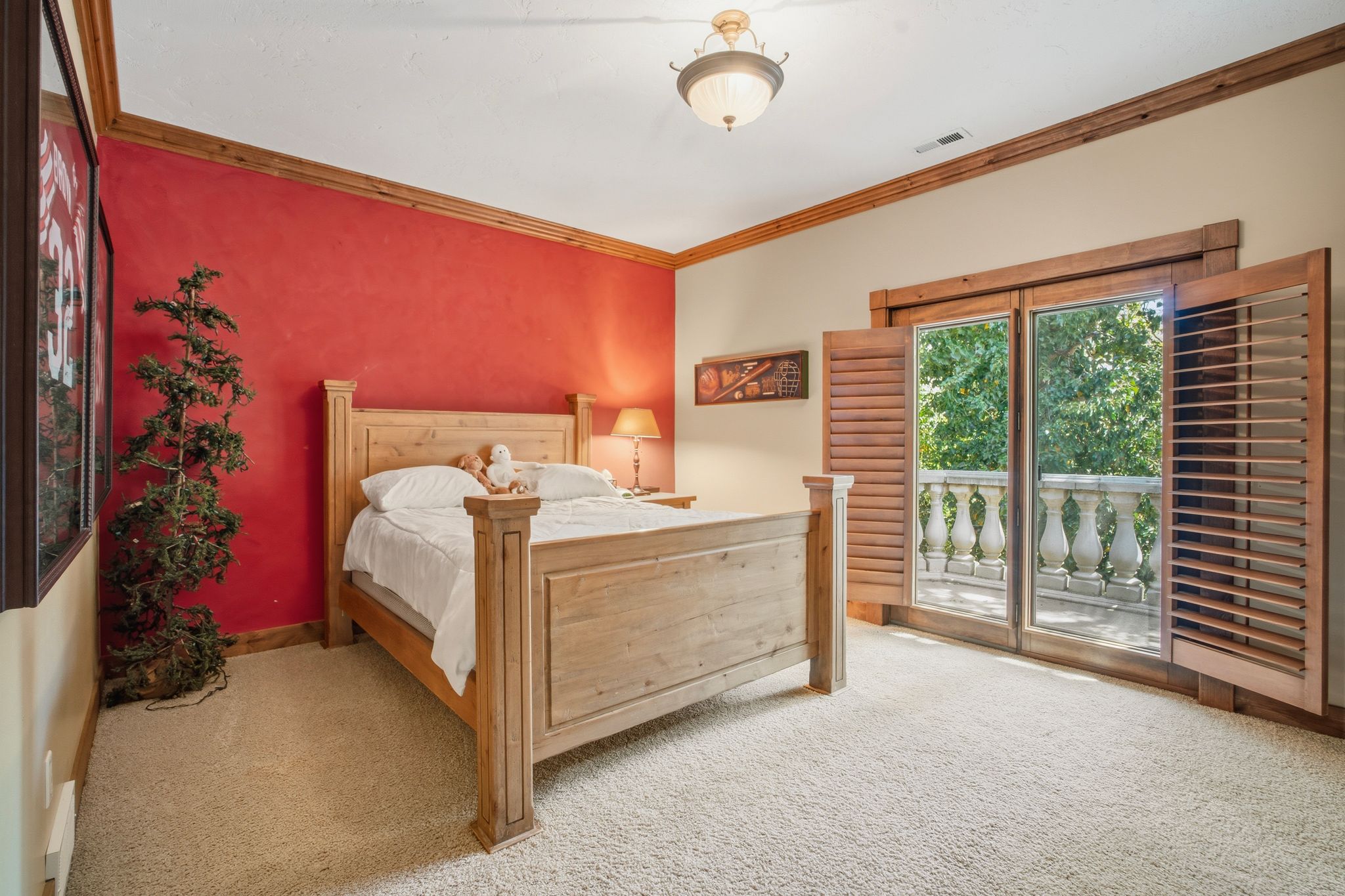 Bedroom featuring light-toned carpet flooring and a prominent red accent wall