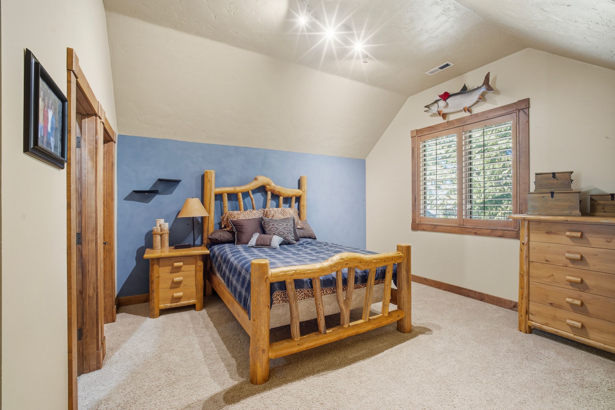 Sloped ceiling room featuring light-colored walls with one accent wall, recessed lighting, and soft carpeting