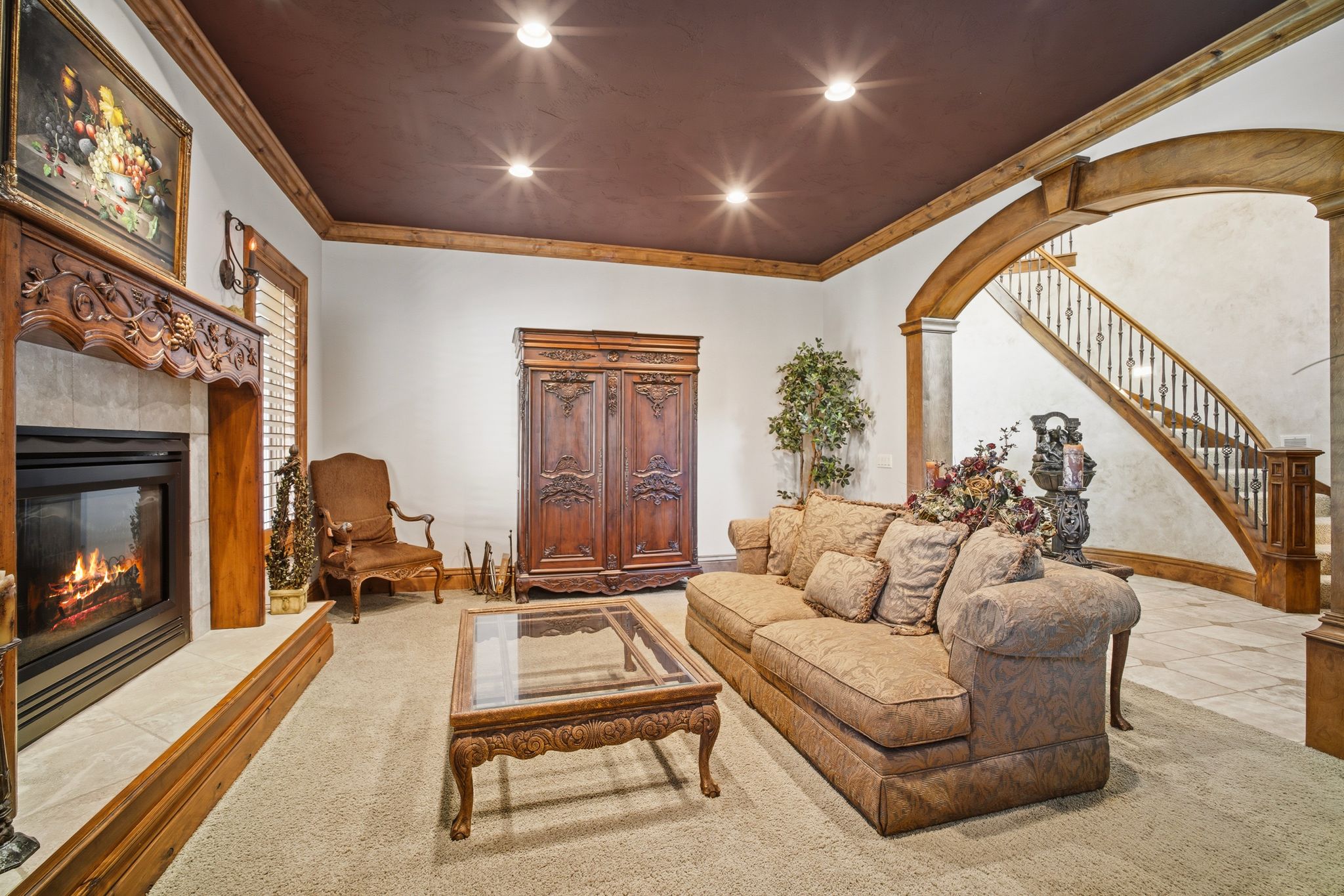 Living area featuring recessed lighting, a fireplace with an ornate wood mantel, wood-finish flooring, and a curved staircase with decorative balusters