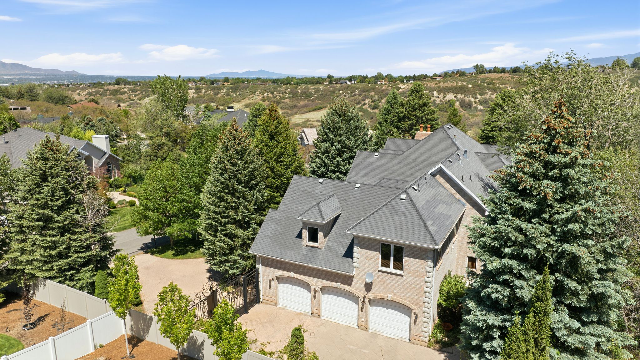 Brick-clad residence featuring a multi-gabled roofline and a three-car garage