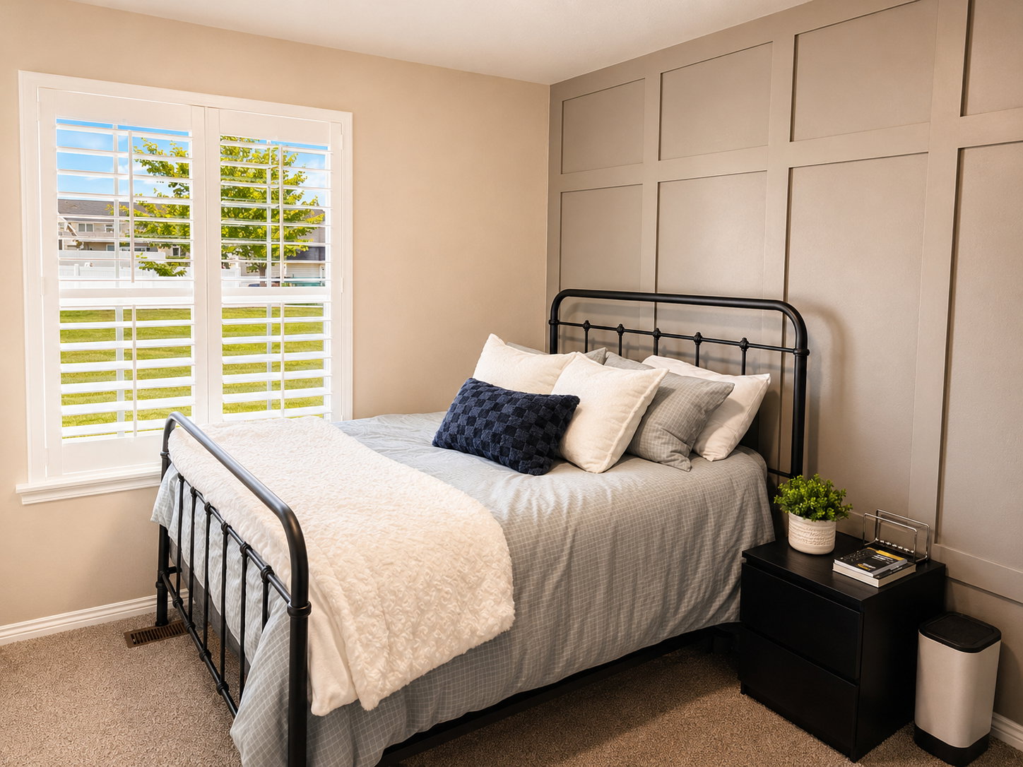 Interior room featuring a window with white plantation shutters, neutral wall paint, and a decorative board and batten accent wall