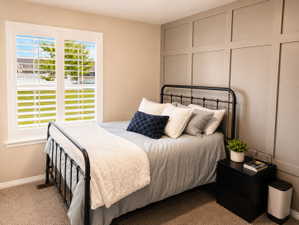 Interior room featuring a window with white plantation shutters, neutral wall paint, and a decorative board and batten accent wall