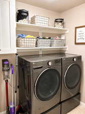 Dedicated laundry area featuring a dual washer and dryer set