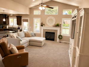Vaulted living room with a ceiling fan and recessed lighting