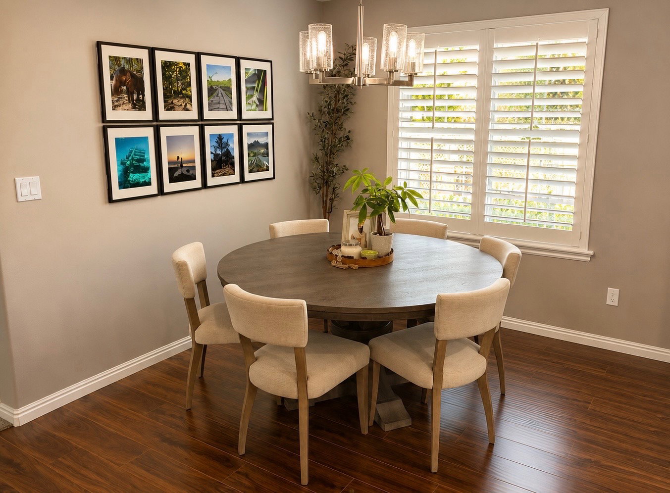 Dining area featuring dark wood-finish flooring, neutral-toned walls, and a window with white plantation shutters