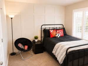 Bedroom featuring a decorative board and batten wall accent